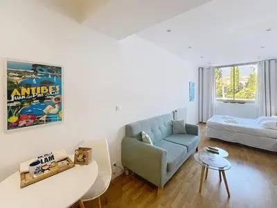 a living room with a couch and a bed at Cannes Heart of town Cozy bright warm & sunny studio by Olam Properties in Cannes