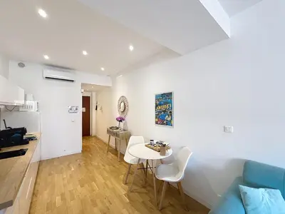 a kitchen and a living room with a table and chairs at Cannes Heart of town Cozy bright warm & sunny studio by Olam Properties in Cannes