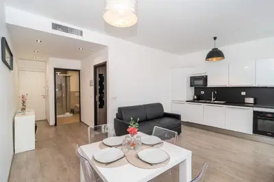 a living room with a white table and a couch at Cosy 1BR Cannes Gambetta hyper centre - Croisette 1 mn - 4 pers by Olam Properties in Cannes
