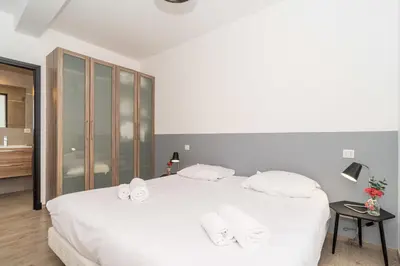 a white bedroom with a large white bed with white towels at Brand new 2 BR Gambetta Fully Renovated 2021- 5 mns Palais by Olam Properties in Cannes