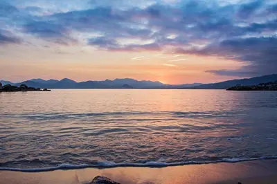 a sunset over a body of water with mountains at Cannes Close Centre 2 BR 2 bath mezzanine & balconies Exceptional Rating Ideal Families Easy parking by Olam Properties in Cannes