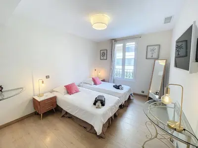 a bedroom with two beds and a mirror at Cannes Close Centre 2 BR 2 bath mezzanine & balconies Exceptional Rating Ideal Families Easy parking by Olam Properties in Cannes