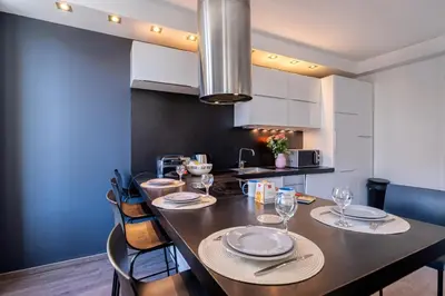 a kitchen with a long table with plates and wine glasses at Heart of Cannes Amazing design apartment Croisette Top Location Best Seller by OIam Properties in Cannes