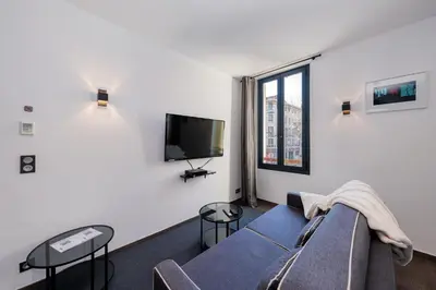 a living room with a couch and a tv at Heart of Cannes Amazing design apartment Croisette Top Location Best Seller by OIam Properties in Cannes