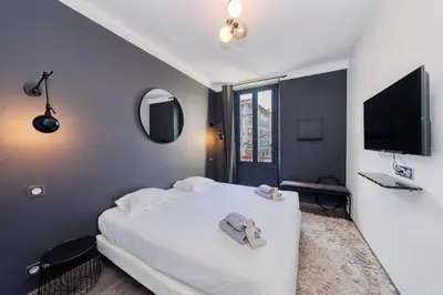 a bedroom with a white bed and a tv at Heart of Cannes Amazing design apartment Croisette Top Location Best Seller by OIam Properties in Cannes
