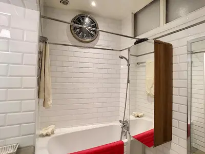 a bathroom with a tub and a clock on the wall at FRGK 