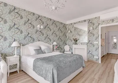 a dining room with a table and chairs and wallpaper at Croisette Palais Miramar Cannes Imperial in Cannes