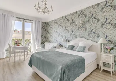 a bedroom with a large bed with purple flowers at Croisette Palais Miramar Cannes Imperial in Cannes