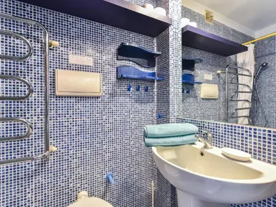 a blue tiled bathroom with a toilet and a sink at Apartment La Brise by Interhome in Cannes