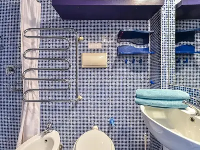 a blue tiled bathroom with a toilet and a sink at Apartment La Brise by Interhome in Cannes
