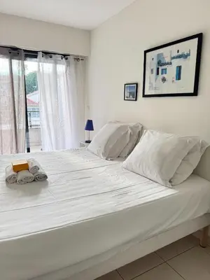 a large white bed in a room with a window at Spacious Luxury apt, 12 min walk to Croisette beach and Conf Centre in Cannes