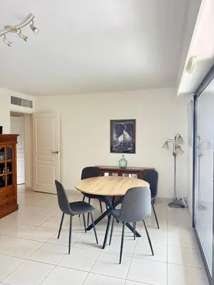 a dining room with a wooden table and chairs at Spacious Luxury apt, 12 min walk to Croisette beach and Conf Centre in Cannes