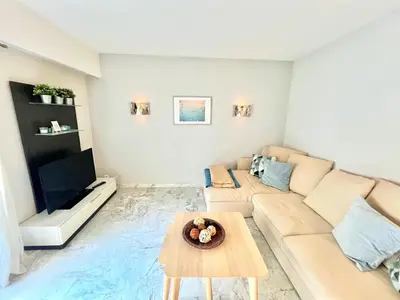 a living room with a couch and a table at Branly 2, by Welcome to Cannes in Cannes