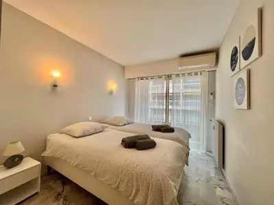 a bedroom with a large bed and a window at Branly 2, by Welcome to Cannes in Cannes