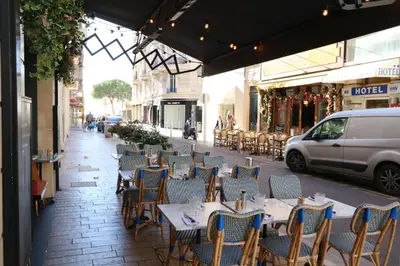 an outdoor restaurant with tables and chairs on a city street at Carré d'Or 1 bedroom 2 mins from Croisette 5 from Palais 243 in Cannes