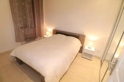 a bedroom with a white bed with two night stands at Carré d'Or 1 bedroom 2 mins from Croisette 5 from Palais 243 in Cannes