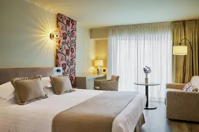 a hotel room with a large bed and a chair at Villa d'Estelle in Cannes