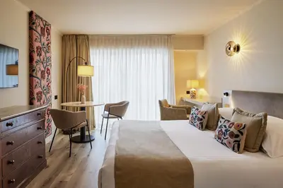 a hotel room with a large bed and a table at Villa d'Estelle in Cannes