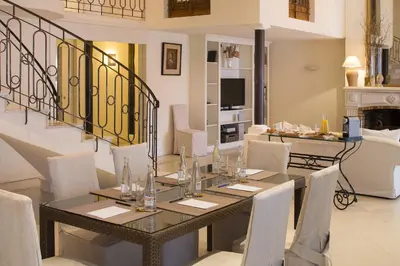 a dining room with a table and white chairs at Villa d'Estelle in Cannes