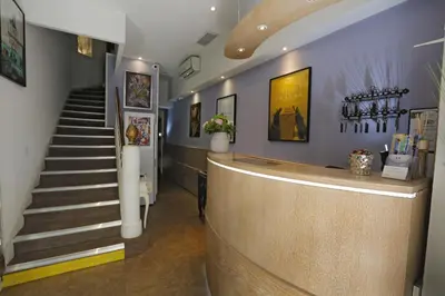 a hotel room with two beds and a desk at Hôtel Alizé in Cannes