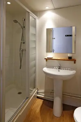 a bedroom with a white bed and a door at Hôtel Alizé in Cannes