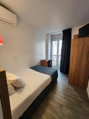 a living room with a table and a kitchen at Hôtel Alizé in Cannes