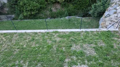a fence in the middle of a grass field at A little Eden in Le Cannet