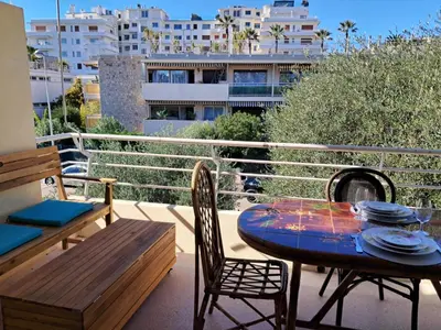 a patio with a table and chairs on a balcony at LES MOUETTES A in Cannes