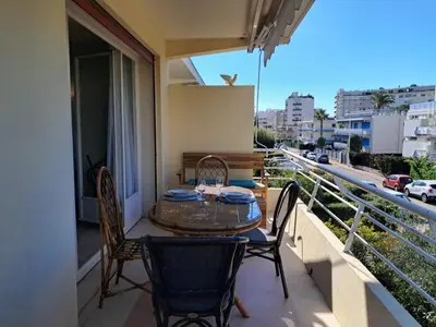 a table and chairs on a balcony with a view of a city at LES MOUETTES A in Cannes