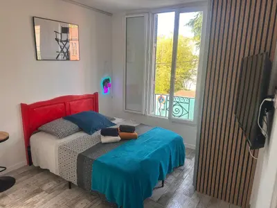 a bedroom with a bed and a large window at Studio and gallery in Cannes