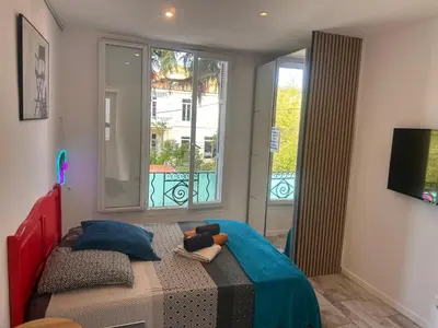 a bedroom with a bed and a large window at Studio and gallery in Cannes