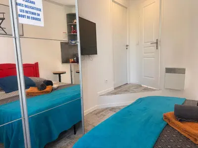 a mirror in a room with a bed and a tv at Studio and gallery in Cannes