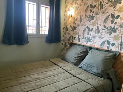 a bedroom with a bed with a flowery wall at ToiTmer in Cannes