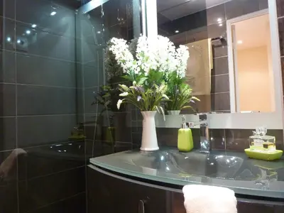 a bathroom with a sink with a vase of flowers on it at ToiTmer in Cannes