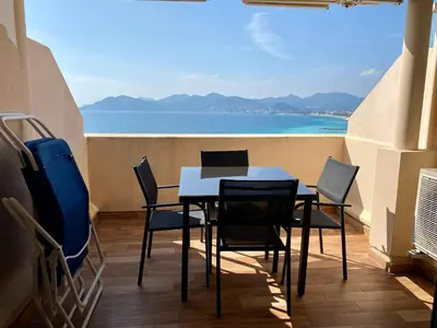 a table and chairs in a balcony with a view of the ocean at ToiTmer in Cannes