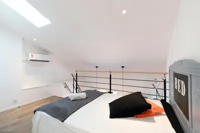 a bedroom with a large bed and a television at Atelier Duplex in Cannes