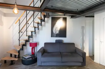 a living room with a couch and a staircase at Atelier Duplex in Cannes