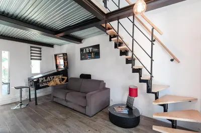 a living room with a couch and stairs at Atelier Duplex in Cannes
