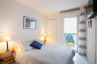 a bedroom with a bed and a window with a chair at Palazzio Vieux Port by Welcome to Cannes in Cannes