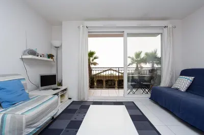 a living room with a blue couch and a balcony at Palazzio Vieux Port by Welcome to Cannes in Cannes