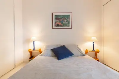 a bedroom with a large bed with two lamps at Palazzio Vieux Port by Welcome to Cannes in Cannes