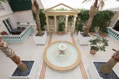 a courtyard with a fountain and palm trees at Palazzio Vieux Port by Welcome to Cannes in Cannes