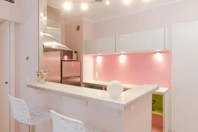a kitchen with white cabinets and a pink wall at Magnifique 2 pièces Palm Beach bord mer in Cannes