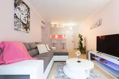 a living room with a couch and a flat screen tv at Magnifique 2 pièces Palm Beach bord mer in Cannes