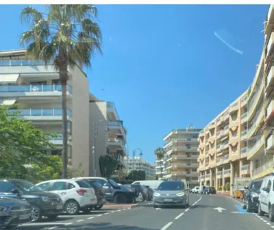 a street with cars parked on the side of the road at Magnifique 2 pièces Palm Beach bord mer in Cannes