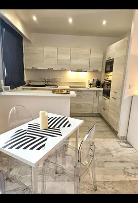 a kitchen with a white table and chairs in a room at La vue d'Azur, élégance et lumière à Cannes in Cannes