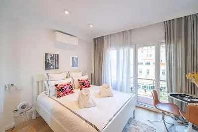 a white bedroom with a large bed and a window at Luxury Apartment - 150m to Palais des Festivals ( Cannes ) in Cannes