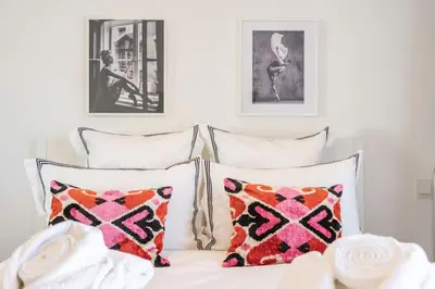 a bed with two pillows and two pictures on the wall at Luxury Apartment - 150m to Palais des Festivals ( Cannes ) in Cannes