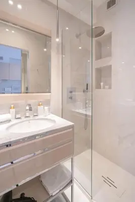 a white bathroom with a sink and a shower at Luxury Apartment - 150m to Palais des Festivals ( Cannes ) in Cannes