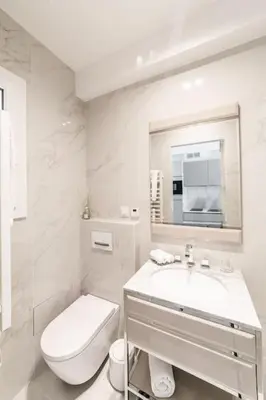 a white bathroom with a toilet and a sink at Luxury Apartment - 150m to Palais des Festivals ( Cannes ) in Cannes